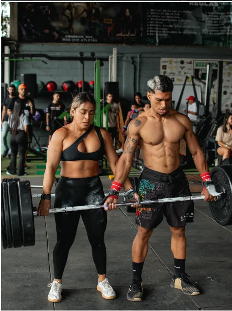 Pareja de atletas haciendo peso muerto en equipo